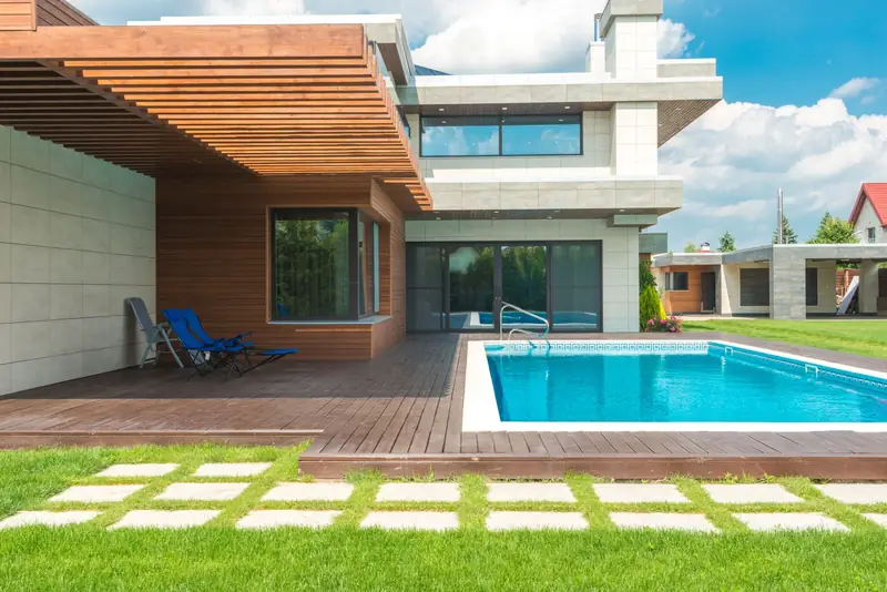 Timber pergola shading a deck beside a swimming pool
